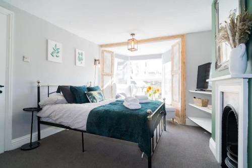 a bedroom with a bed with a green blanket at Stunning 3 bed Home, 5 mins from Margate Beach in Kent