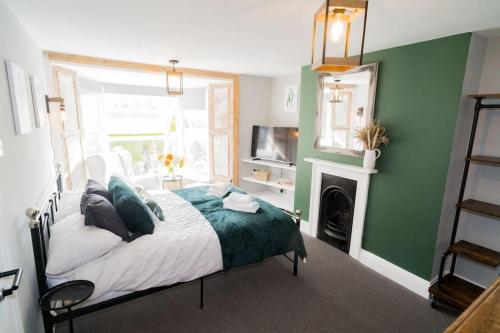 a bedroom with a bed with a green wall at Stunning 3 bed Home, 5 mins from Margate Beach in Kent