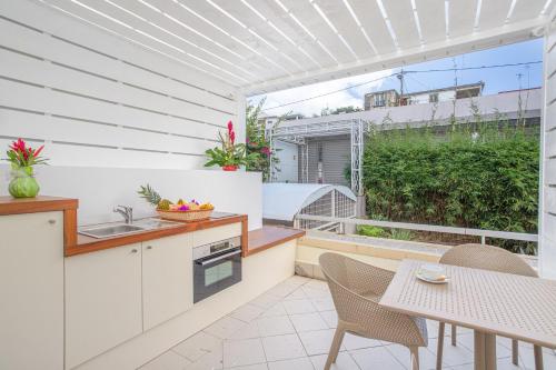 a kitchen with a table and chairs and a balcony at Karibea Squash Hôtel in Fort-de-France