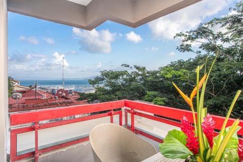 a balcony with a red railing and a view of the ocean at Karibea Squash Hôtel in Fort-de-France