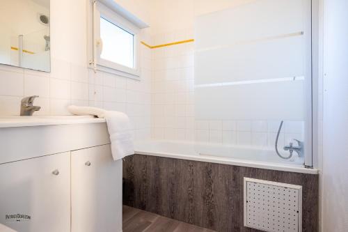 a bathroom with a sink and a bath tub at Apparthôtel Mont Saint Michel - Résidence Fleurdumont in Beauvoir