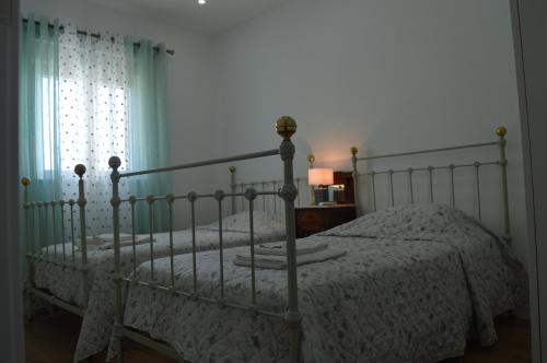 een slaapkamer met twee bedden en een raam bij Quinta das Figueiras in Vila Nova de Cacela
