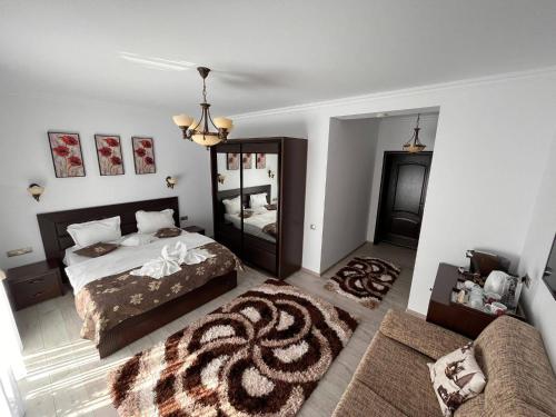 a bedroom with a bed and a mirror and a couch at Casa Hera in Sinaia