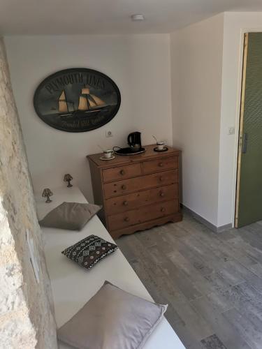 sypialnia z łóżkiem i komodą z obrazem na ścianie w obiekcie Le Pigeonnier de coupiac w mieście Gourdon