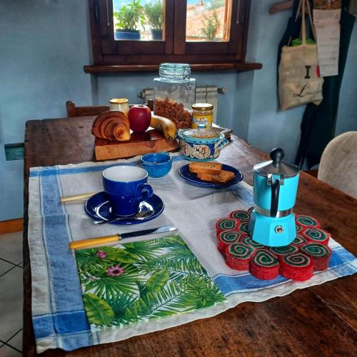 a table with a table cloth with a tea set on it at La casa di Ciaccia in Camaiore