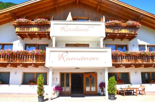 a building with flowerpots on the balconies and the name of a hotel at Residence Rumanon in Ortisei