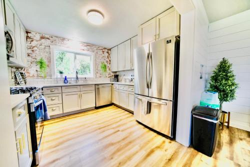 a kitchen with a stainless steel refrigerator and wooden floors at Modern Boho Retreat in Corvallis