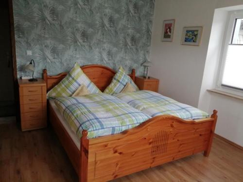 Schlafzimmer mit einem Holzbett mit einem Kopfteil aus Holz in der Unterkunft Fewo1926 in Mertesdorf