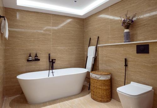 杜拜的住宿－Signature Residence - The Palm Jumeirah，浴室配有白色浴缸和卫生间。
