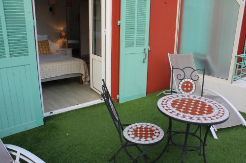 um quarto com uma mesa e cadeiras e um quarto em Hôtel La Villa des Oliviers em Cagnes-sur-Mer