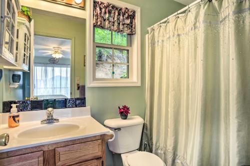 a bathroom with a toilet and a sink and a window at Cozy North Carolina Abode - Deck, Grill and Fire Pit in Burnsville