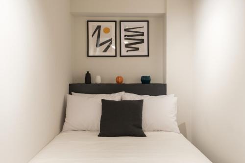 a white bedroom with a bed with white pillows at Voda Luxury Residence #001 in Athens