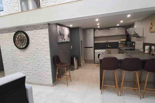a kitchen with a table and chairs in a room at Sweet LOFT A PERIGNAT !!! in Pérignat-sur-Allier