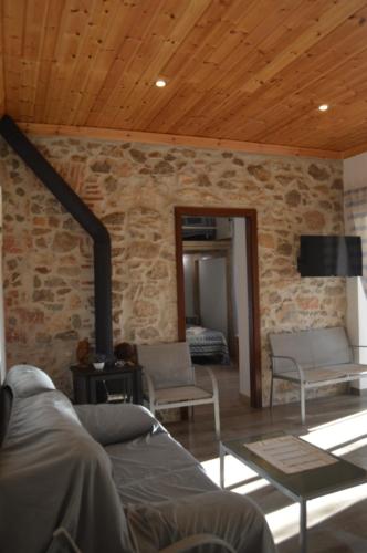 a living room with a stone wall at Quinta das Figueiras in Vila Nova De Cacela