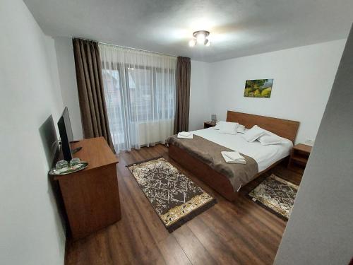 1 dormitorio con 1 cama y TV en Casa Elena, en Ceahlău