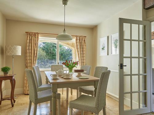 a dining room with a table and chairs and a window at Rosedale in Pickering