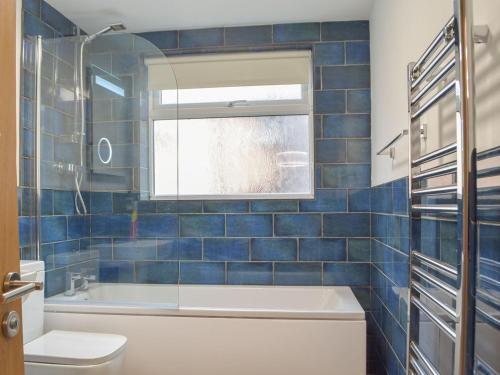 baño con bañera, aseo y ventana en Castle Street Cottage, en Narberth