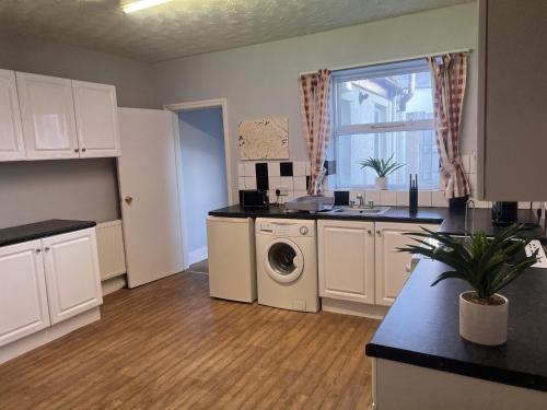eine Küche mit Waschmaschine und Trockner im Zimmer in der Unterkunft ST Nic House in Carlisle