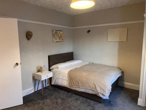 ein Schlafzimmer mit einem Bett und einem Nachttisch mit einem Bett von sidx sidx sidx sidx sidx in der Unterkunft ST Nic House in Carlisle