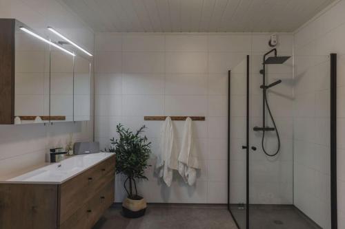 a bathroom with a shower and a sink and a shower at Fabrikken in Bleik