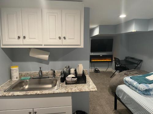 una cocina con fregadero y una cama en una habitación en Downtown Suite - Close to Topgolf, Horseshoe Casino, UM Baltimore en Baltimore