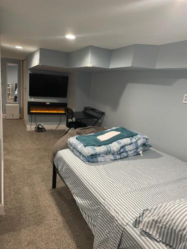a bedroom with two beds and a flat screen tv at Downtown Suite - Close to Topgolf, Horseshoe Casino, UM Baltimore in Baltimore