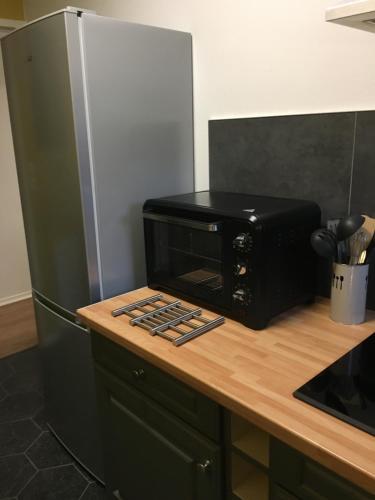 un four micro-ondes installé au-dessus d'un comptoir de cuisine dans l'établissement Appartement Face à la mer, à Wimereux