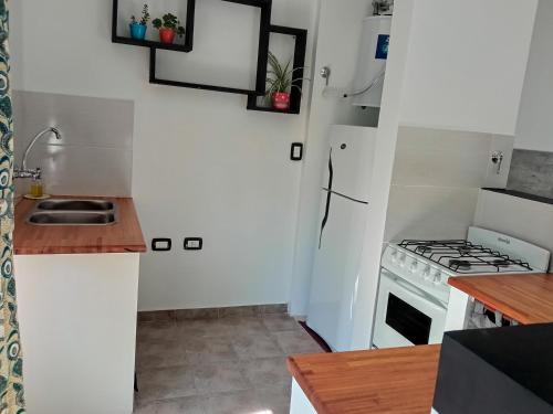 a small kitchen with a stove and a sink at Santa Teresita Sobre El Monte in Santa Teresita