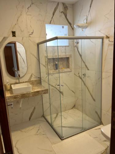 a bathroom with a glass shower and a sink at Casa com piscina em Coroa Vermelha in Santa Cruz Cabrália
