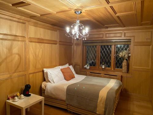 um quarto com uma cama e um lustre em The GateHouse at Stansted em Hallingbury