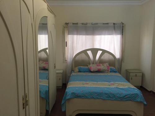 1 dormitorio con cama y ventana grande en ڤيلا الميراچ Meriage en El Cairo