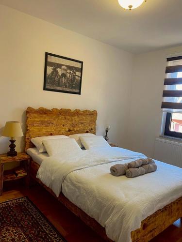 um quarto com uma cama grande e uma cabeceira em madeira em APARTMENTS VRANAS Bjelašnica em Bjelašnica
