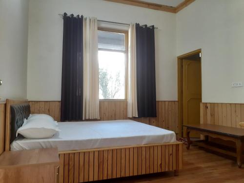 sypialnia z dużym łóżkiem i oknem w obiekcie Gazing Moon Homestay w mieście Shamshi