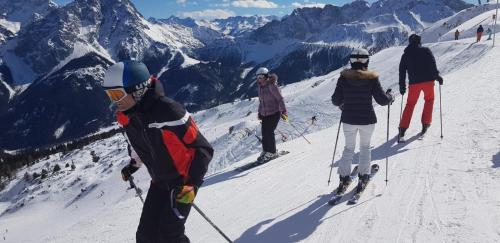 a group of people skiing down a snow covered mountain at Chalet Panorama Tirol in Hofen