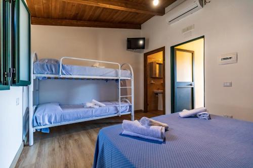 a bedroom with two bunk beds in a room at Villaggio Residence Pietra Grigia in Marina di Camerota