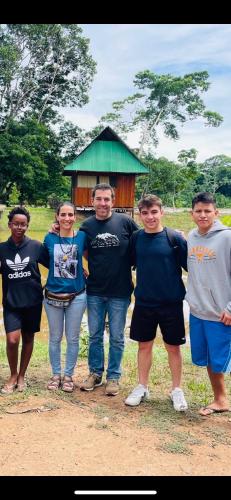 a group of people standing in front of a house at Sunrise of Tambopata in Puerto Maldonado