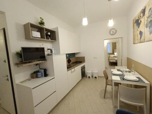 una pequeña cocina y comedor con una mesa y una habitación en FirstHouse - nel centro storico con Parcheggio Gratuito, en Siena