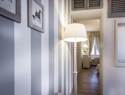 un pasillo con una lámpara de pie y una pared a rayas en Como Unique View - byMyHomeinComo, en Como