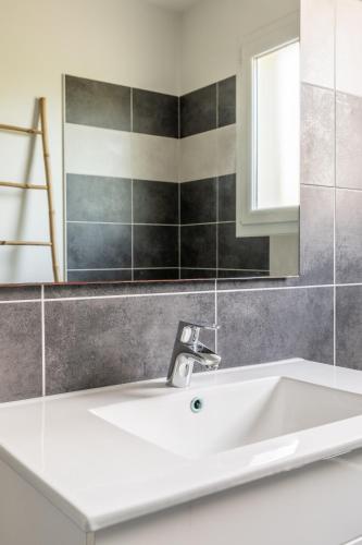 une salle de bain avec un lavabo blanc et un miroir dans l'établissement LA VILLA LANDAISE, à Sainte-Eulalie-en-Born
