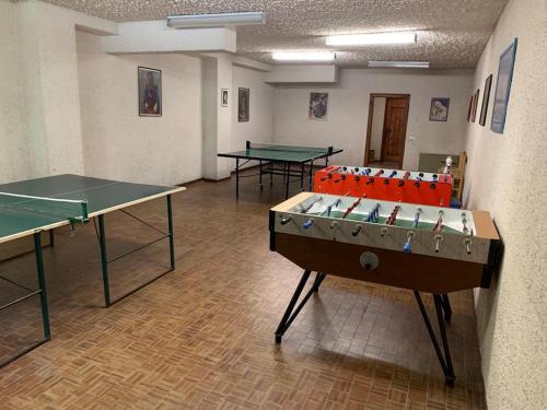 2 mesas de ping pong en una habitación con pelotas de ping pong en Piccolo Rifugio di Foppolo, en Foppolo