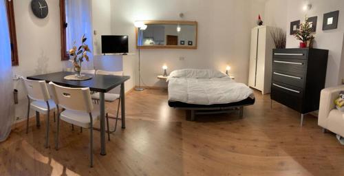 1 dormitorio con 1 cama, mesa y sillas en Piccolo Rifugio di Foppolo en Foppolo