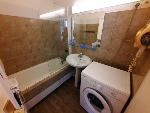 une salle de bain avec un lavabo et une machine à laver dans l'établissement Plage du Chay, à Royan