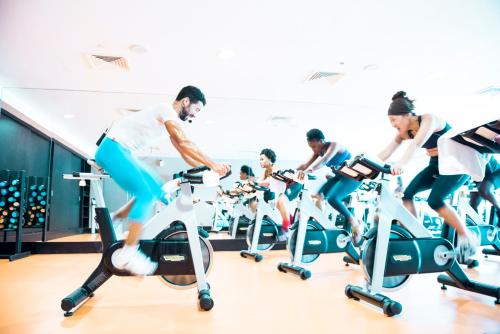 a group of people exercising on exercise bikes in a gym at EPIC SANA Luanda Hotel in Luanda