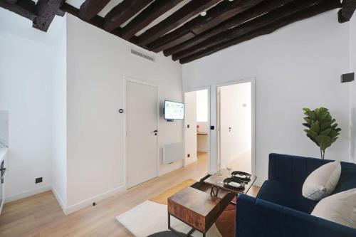 ein Wohnzimmer mit einem blauen Sofa und einem Tisch in der Unterkunft Lovely 2BR - Near La Sorbonne & Quartier Latin in Paris