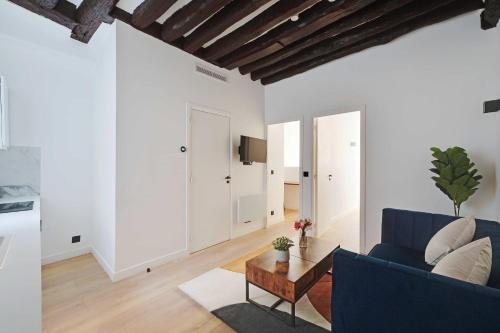 ein Wohnzimmer mit einem blauen Sofa und einem Tisch in der Unterkunft Lovely 2BR - Near La Sorbonne & Quartier Latin in Paris