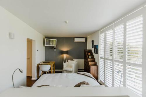 a bedroom with a bed and a desk and a chair at B&B Villa Tartine in Puurs