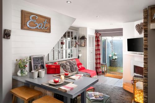 a living room with a table and a red couch at The Nest Barnlette in Wrenbury