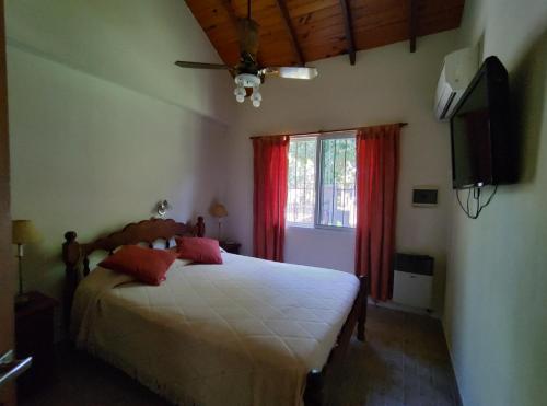 1 dormitorio con 1 cama, TV y ventana en Alojamientos Estrellas Azules en Colón