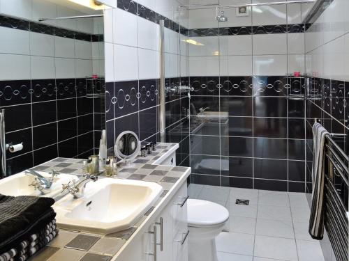 a black and white bathroom with a sink and a toilet at Spout Crag Boathouse in Far Sawrey