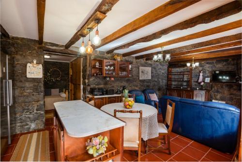 comedor con mesa y sillas azules en Stone House ''Vista'' By Atlantic Holiday, en São Vicente